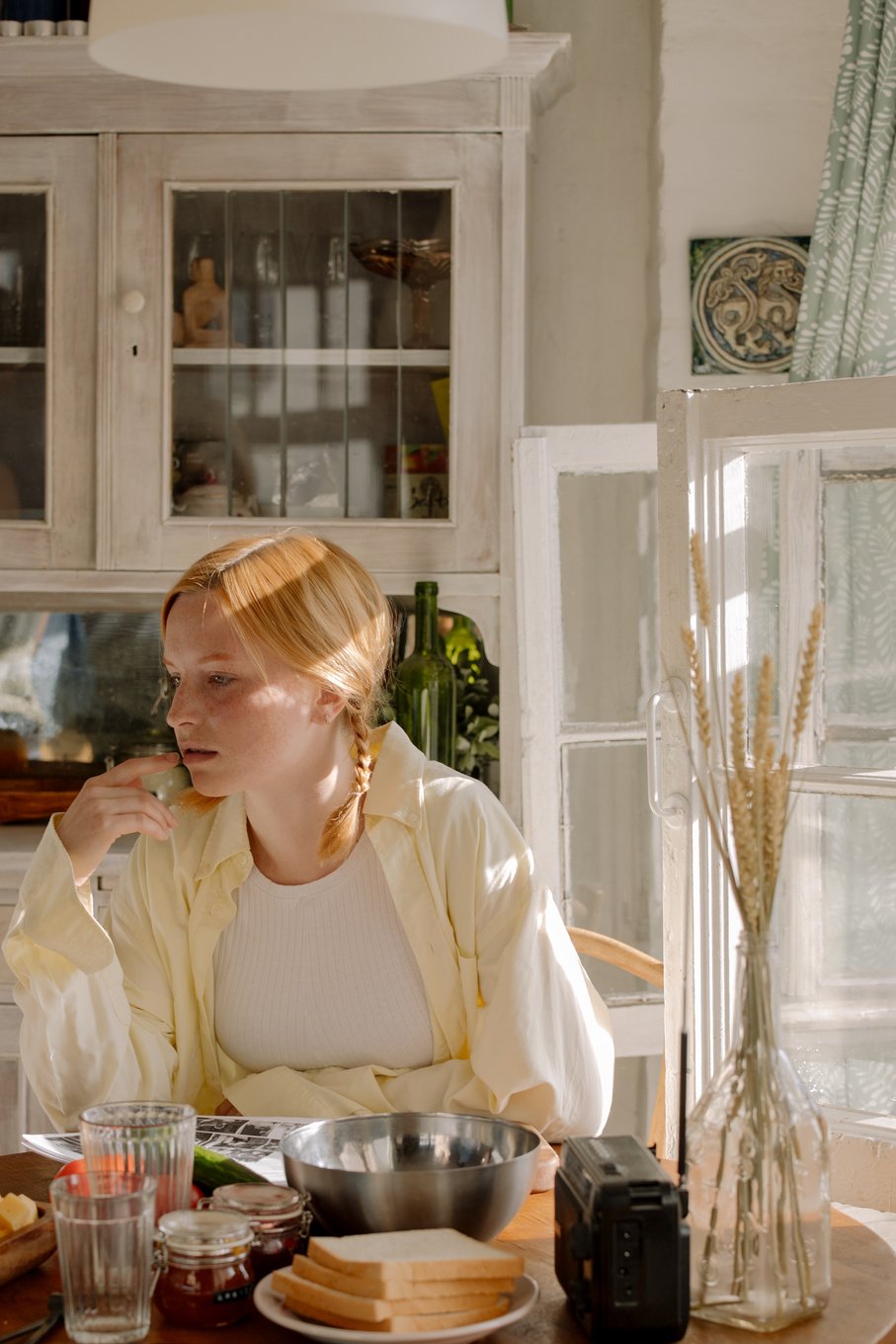 Woman in White Long Sleeve Shirt Sitting on Chair